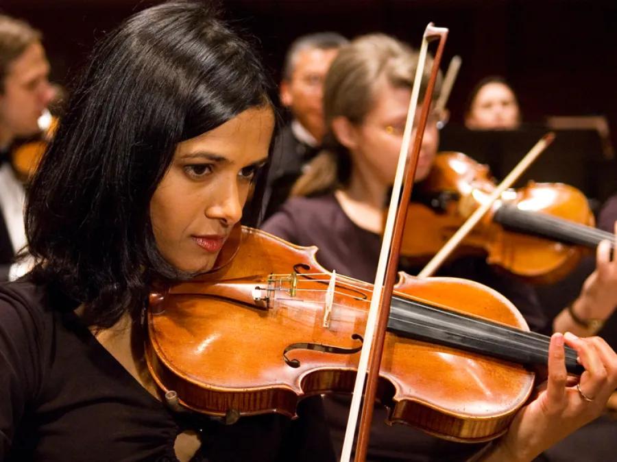 diverse woman playing the violin at a concert