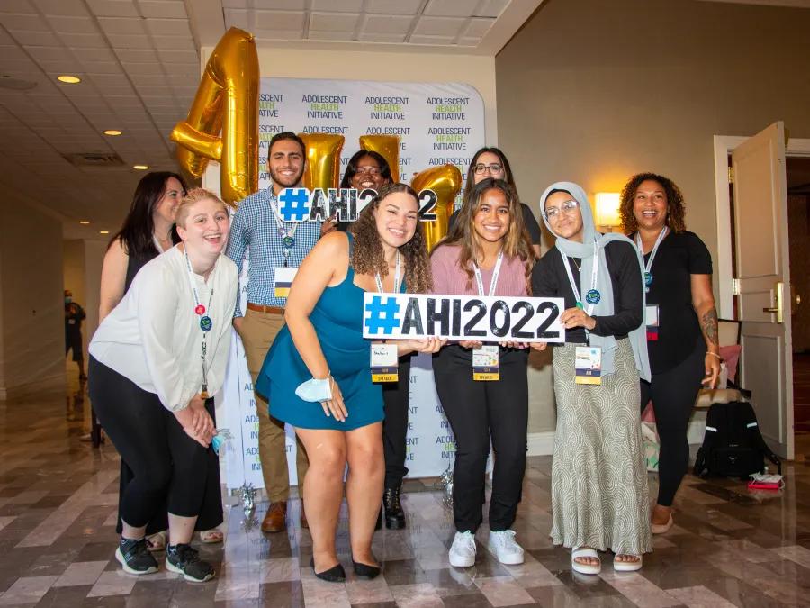 Group of diverse teens holding sign reading #AHI2022