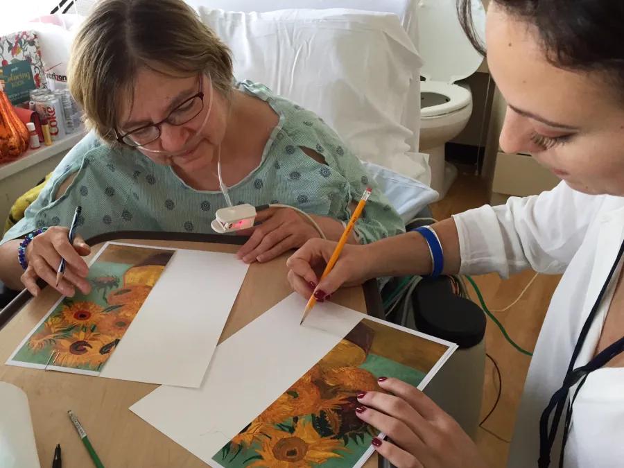 A patient draws as part of the bedside art program