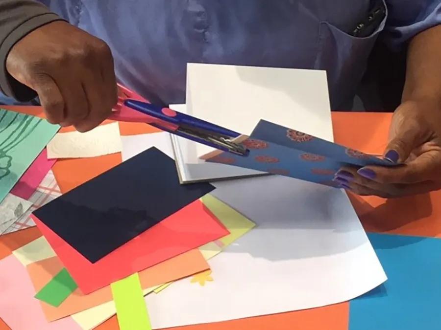 Black hands with scissors and art supplies