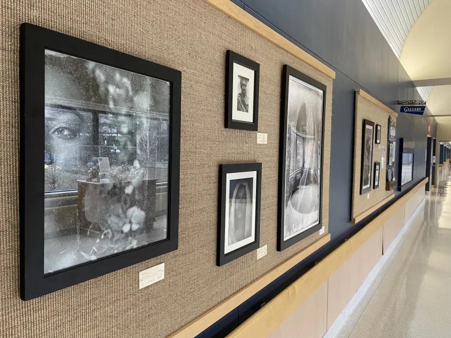 Photographs of people line the gallery along the hospital corridor