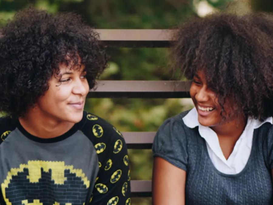 Two young women smile at each other
