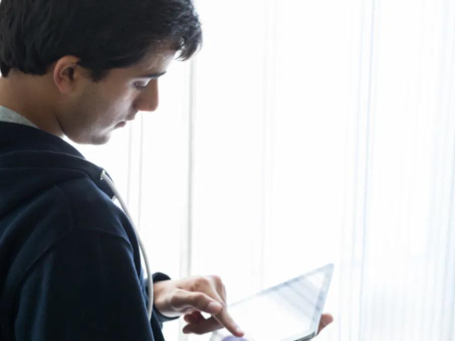 teen boy looks at ipad