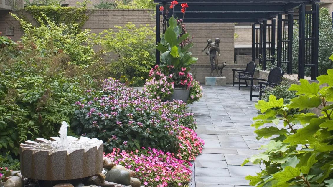 Garden with with fountain and paved pathway leading up to sculpture