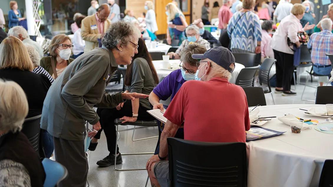 Group of elderly people discussing and taking notes.