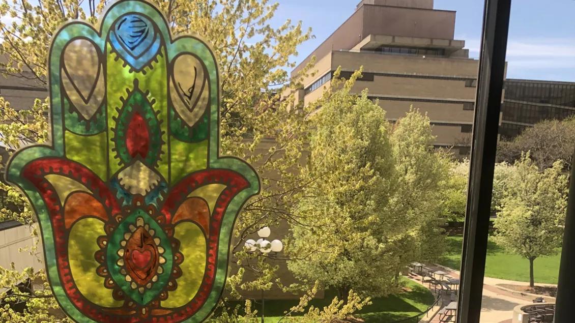 Sun shines through a colorful Hamsa Hands window decal