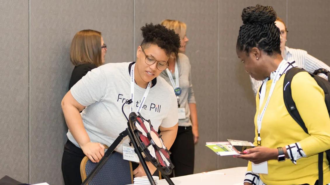 Two folks engaged at a spoex exhibit at the Annual Conference on Adolescent Health