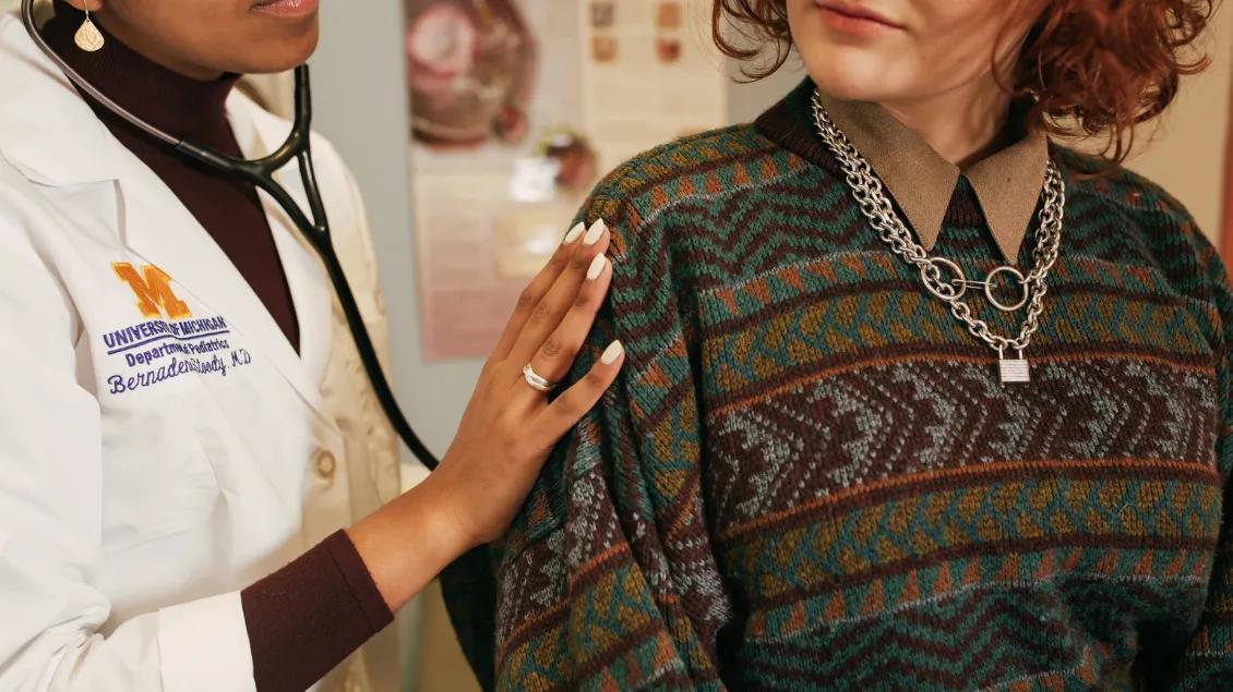 Doctor examines teen patient's breathing