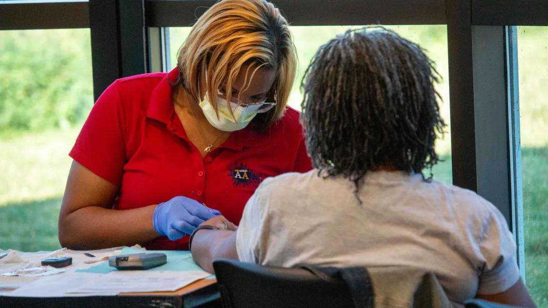 volunteer examines someone at flu clinic