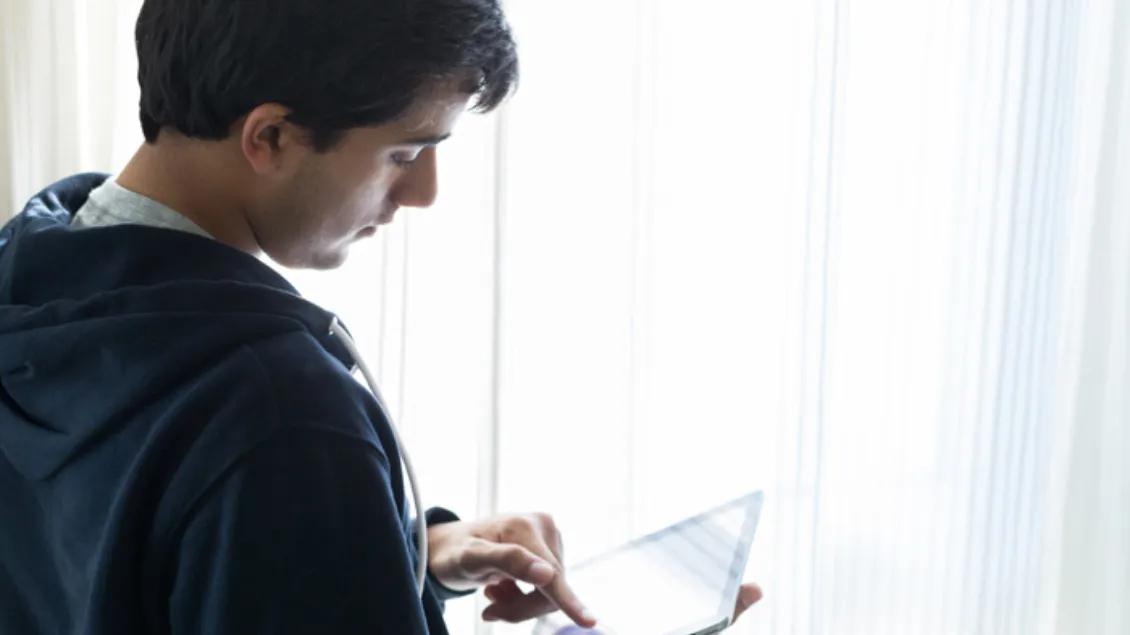 teen boy looks at ipad