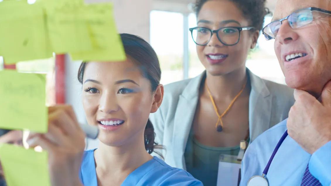 Group of medical professionals looking at sticky notes.
