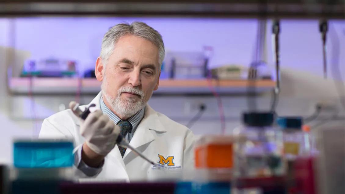 Henry Paulson, M.D., Ph.D., working in a laboratory.