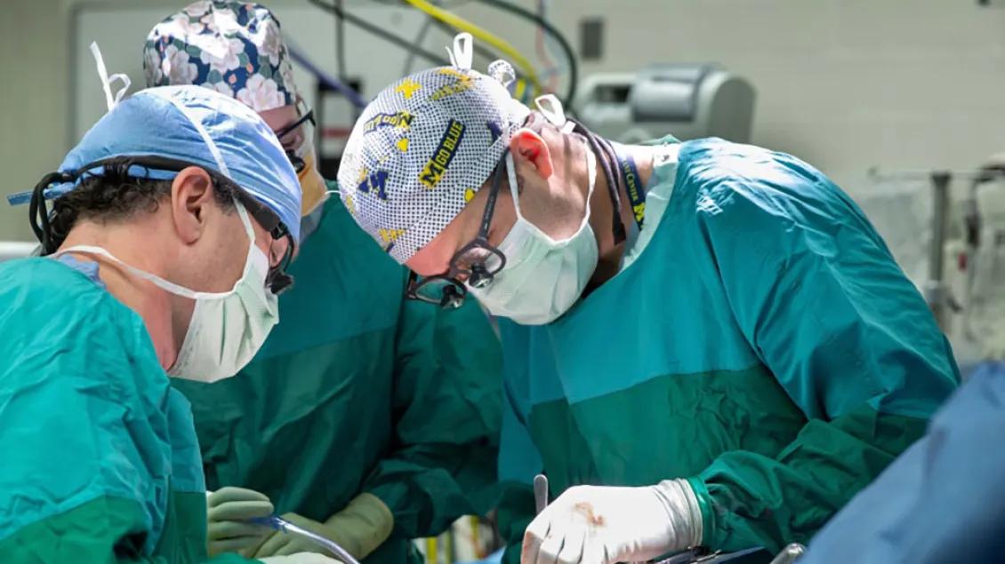 Three surgeons performing a liver transplant.