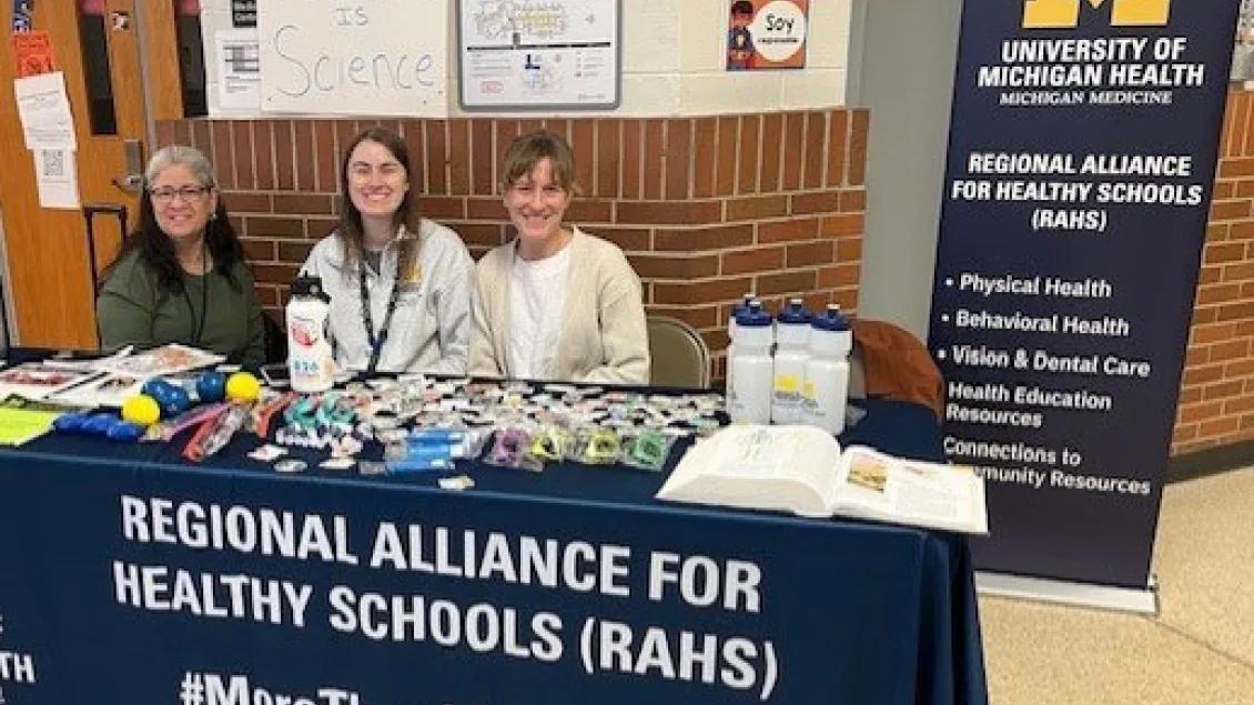 Three RAHS staff working at a table at a community health event.