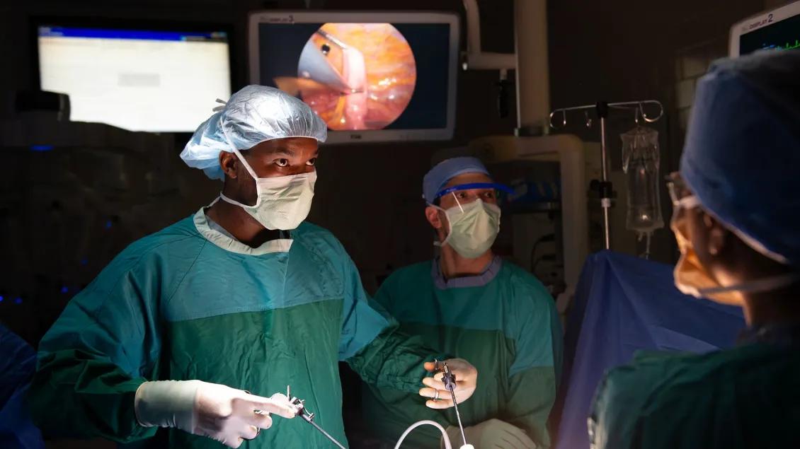 Three thoracic surgeons perform a procedure in an operating room.