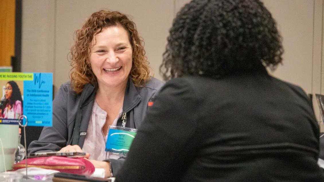 An attendee at the 2025 Connection Session smiles while in conversation.