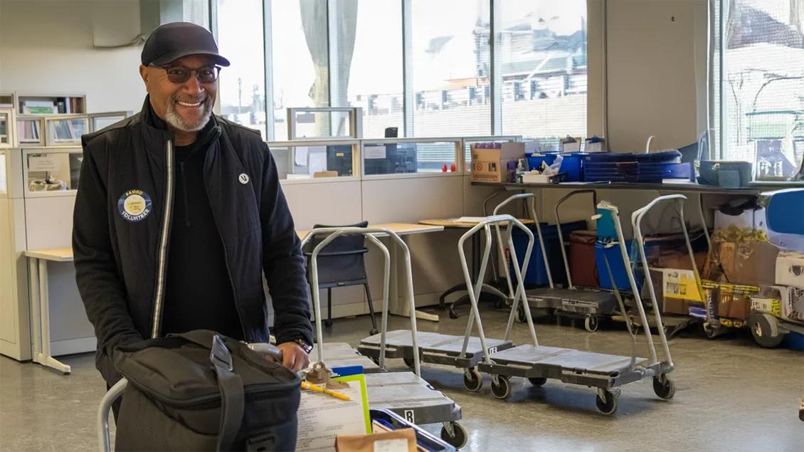 AAMOW volunteer man with a cart of food.