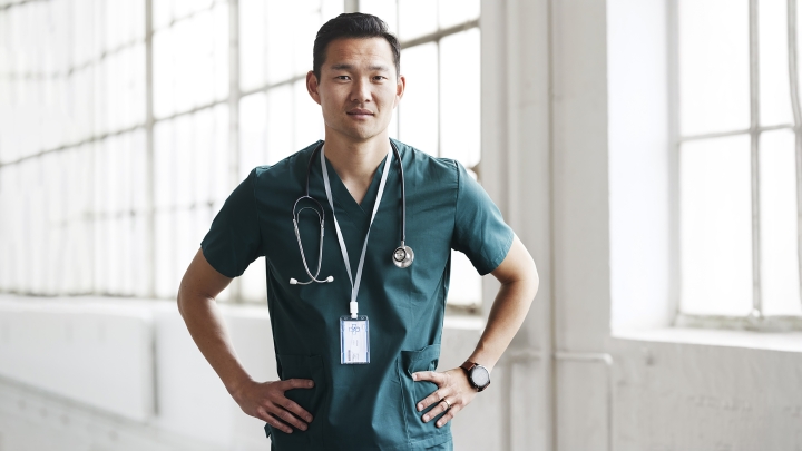 Male Asian health care professional in green scrubs with stethoscope