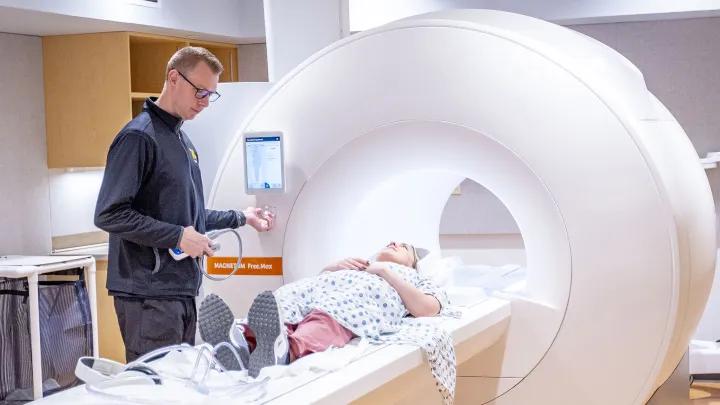 Radiology technologist with patient entering a CT scanner