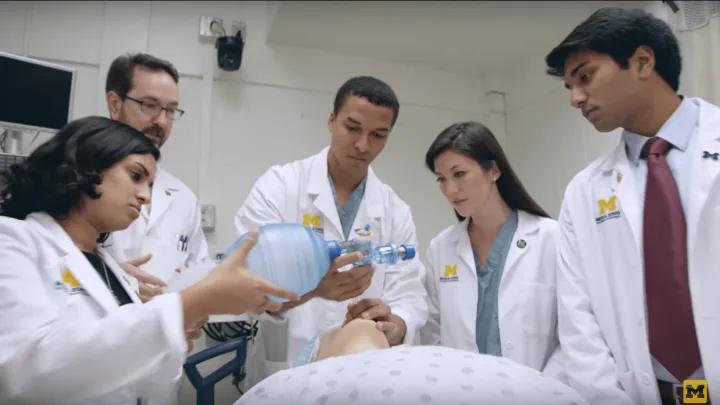 Group of diverse male and female doctors practicing on a medical dummy