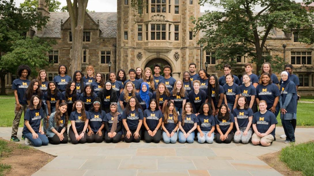 Group photo of students wearing t-shirts with block M logo in front of U-M Law School