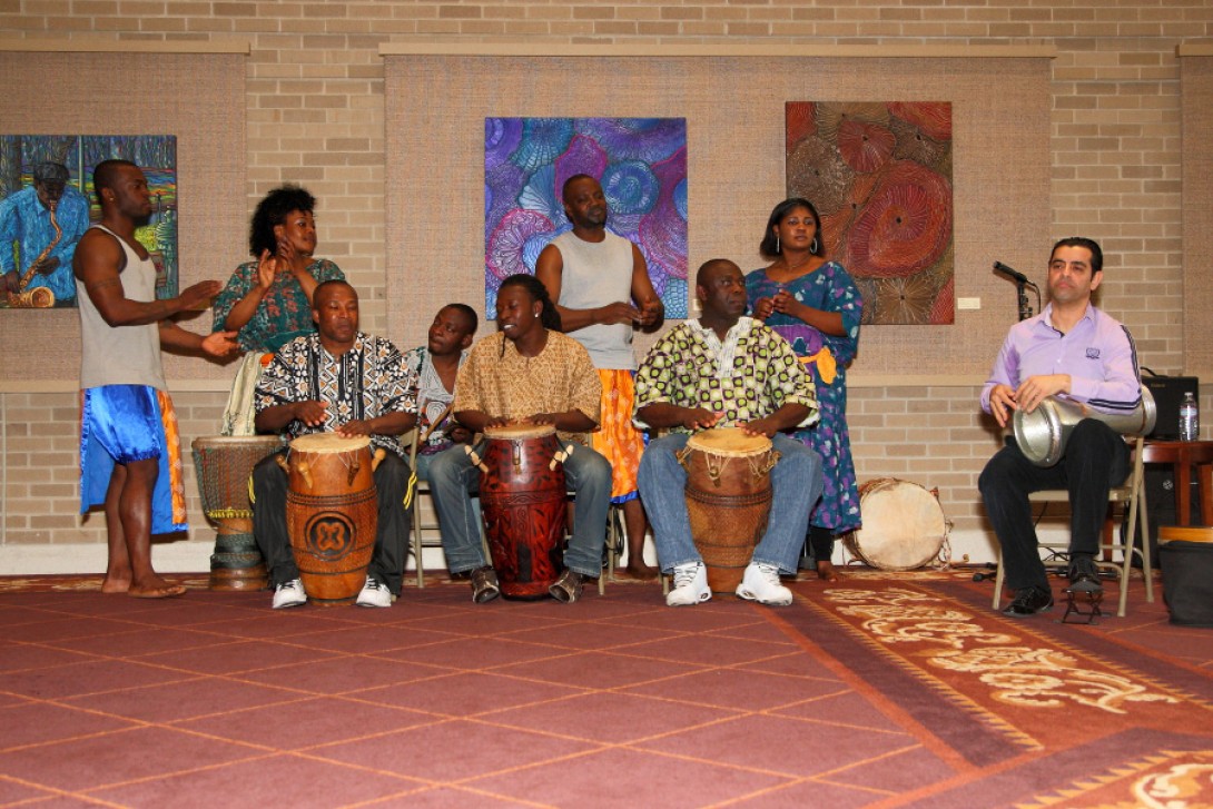 Group o fBlack musicians with wooden drums in front of artwork
