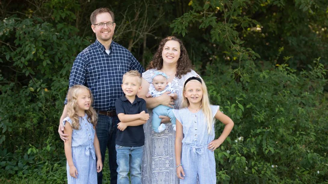 Family smiling in picture trees in background