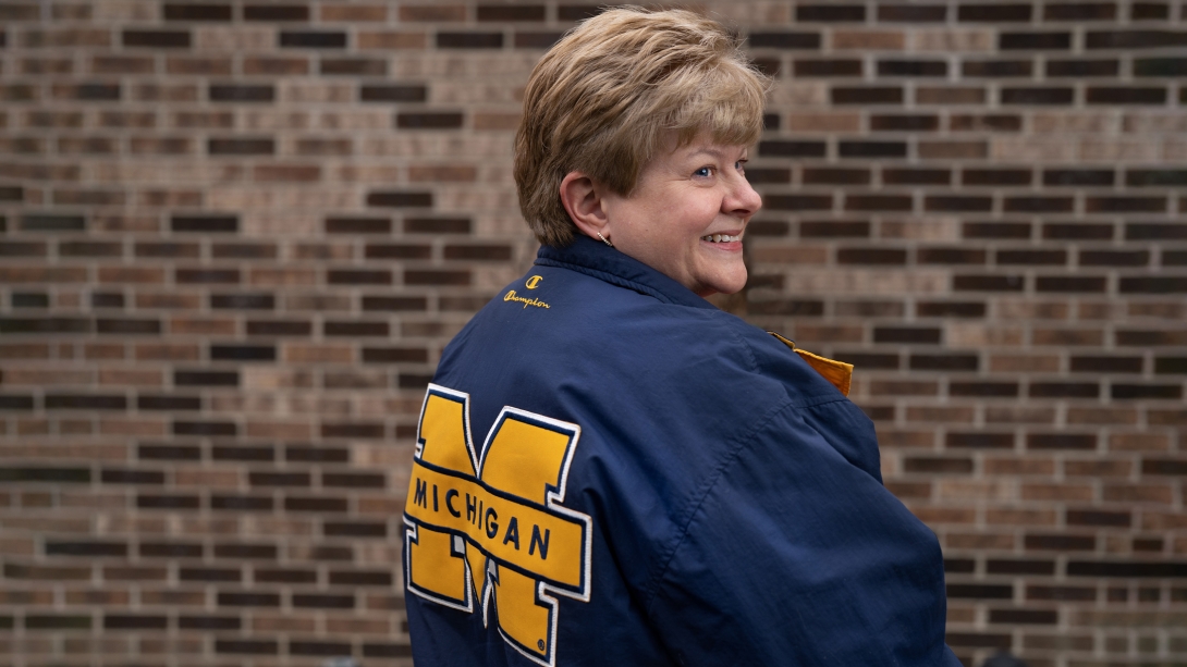 woman turning with michigan logo jacket