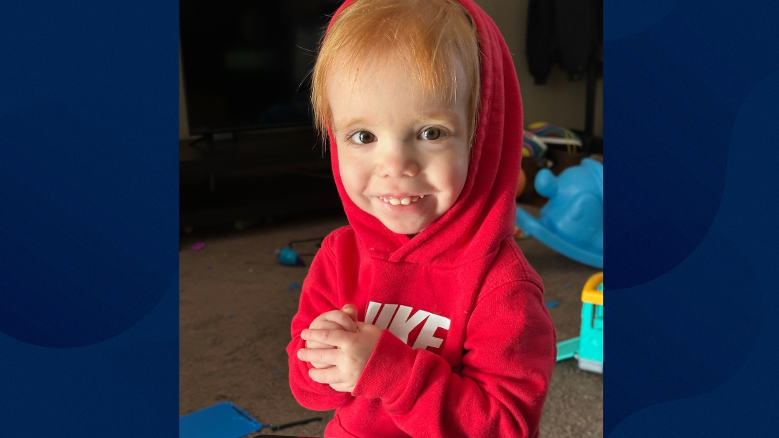 little boy in red sweatshirt smiling