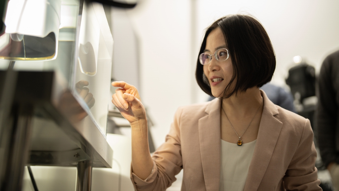 woman pointing in lab with suit jacket on