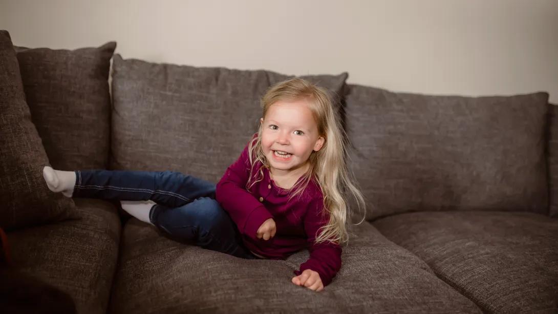 little girl giggling on couch 
