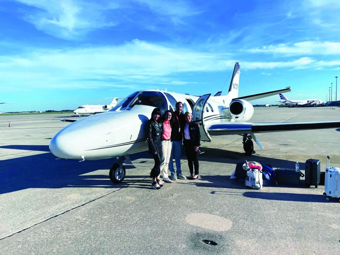 Michael Seidman and his family standing in front of a small airplane.