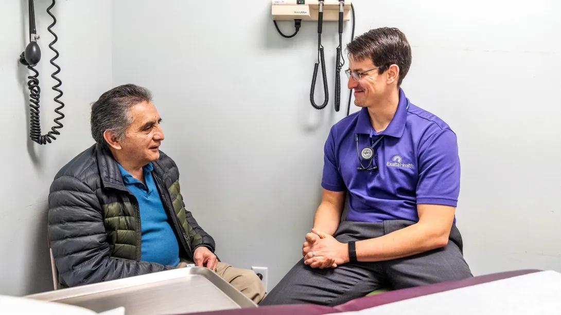 Exalta Health provider works with a patient in an exam room.