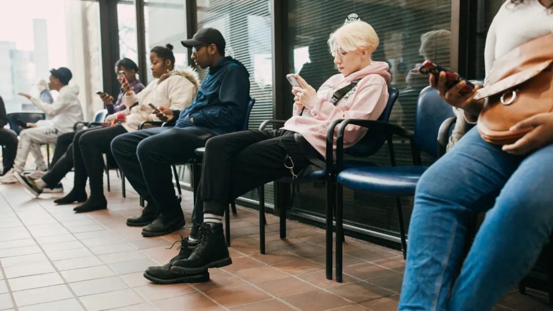 Teens sit in a waiting room