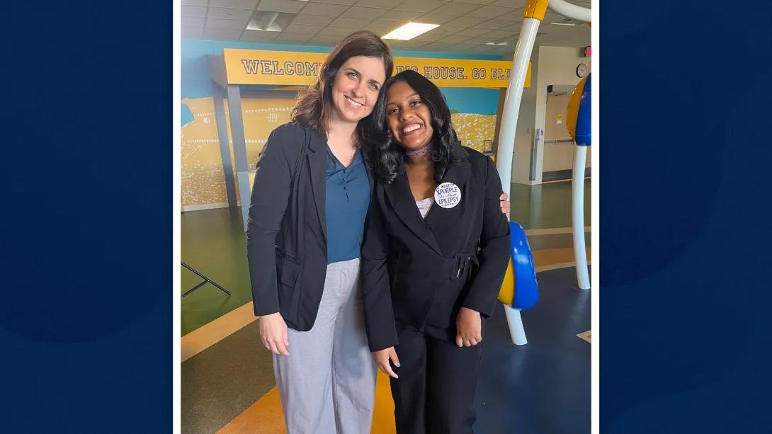 two people standing together smiling at camera