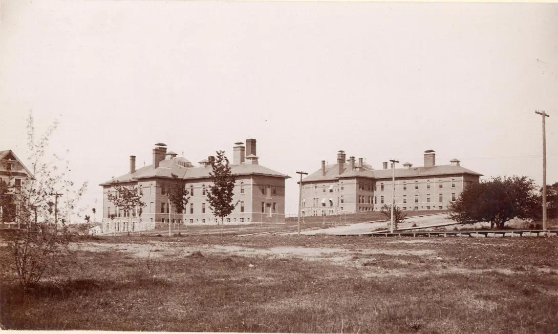 Two similar buildings built in 1891 on Catherine St. (The western building had a straight north facade; the eastern building had a rounded north facade). From 1891-1900, the western building housed the Homeopathic Hospital (also called the Medical Ward) and the eastern building housed the Allopathic Hospital (also called University Hospital). 