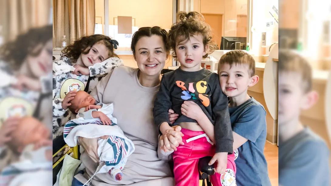 kids with mom meeting baby smiling at camera