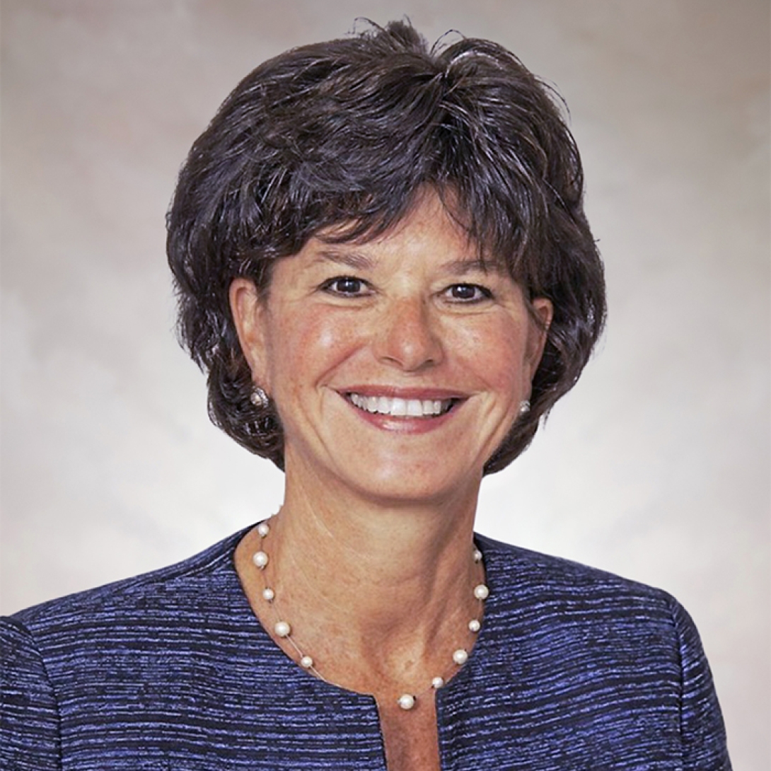 Margaret Dimon, PhD, head and shoulders shot of smiling white woman with short dark hair wearing dark blue jacket and pear necklace