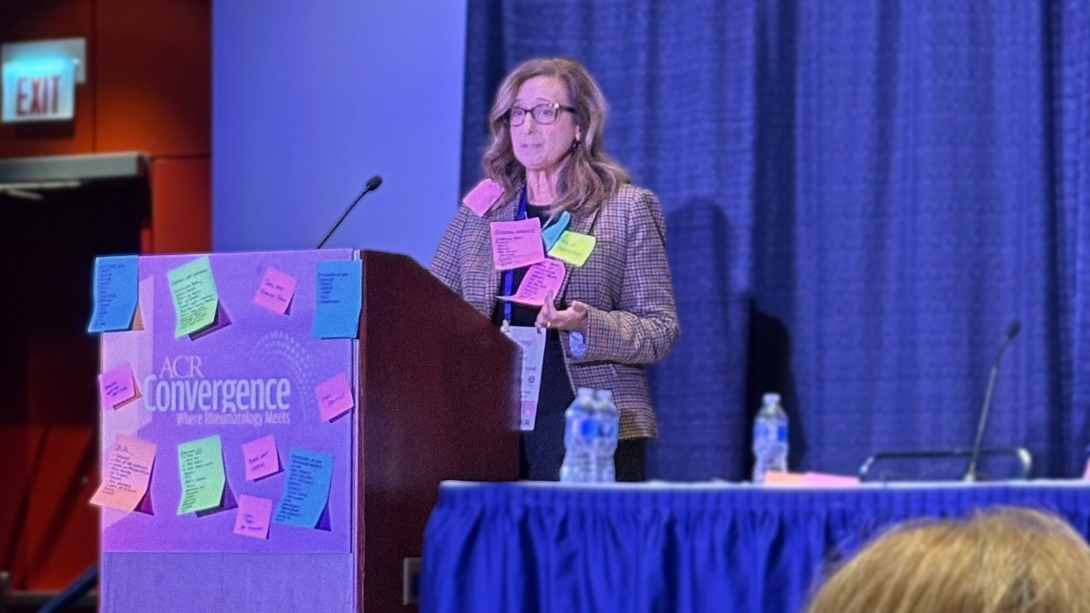 woman standing on stage with sticky notes 