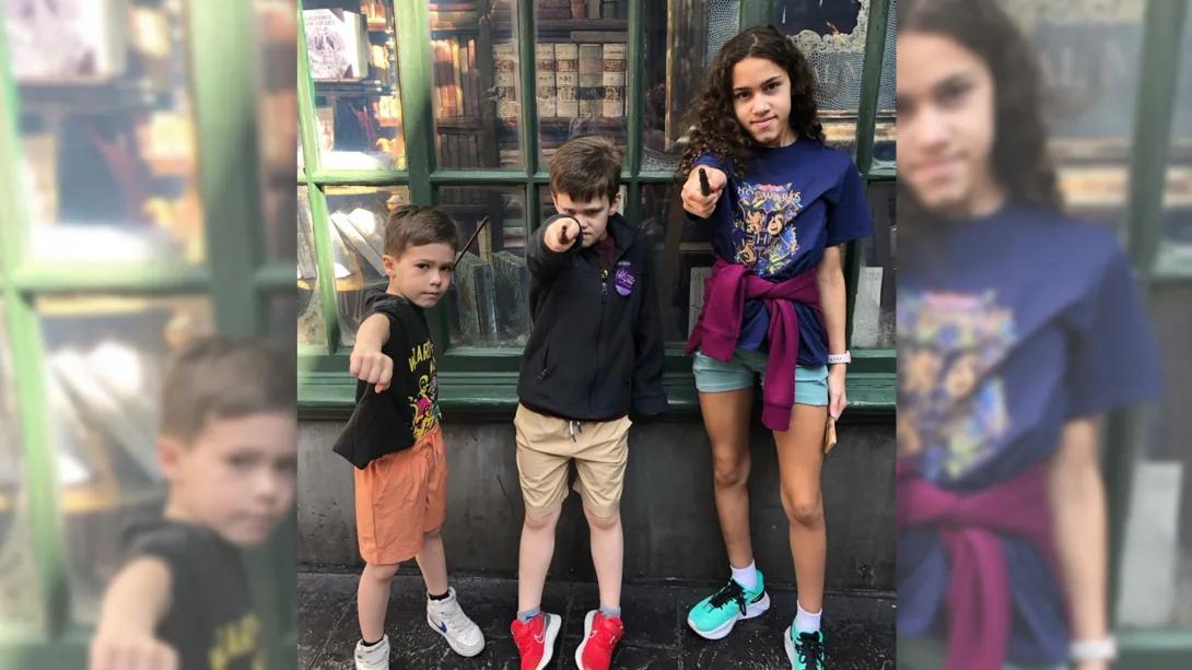 3 kids pointing wizard wands at camera 