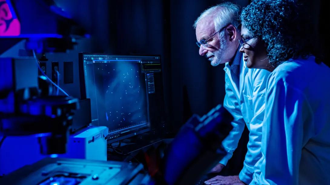 scientists looking at screen blue glow dark white coats on