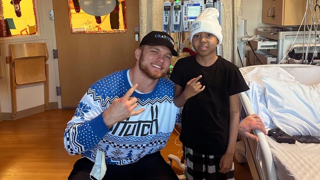 nfl football standing with little boy in hospital room