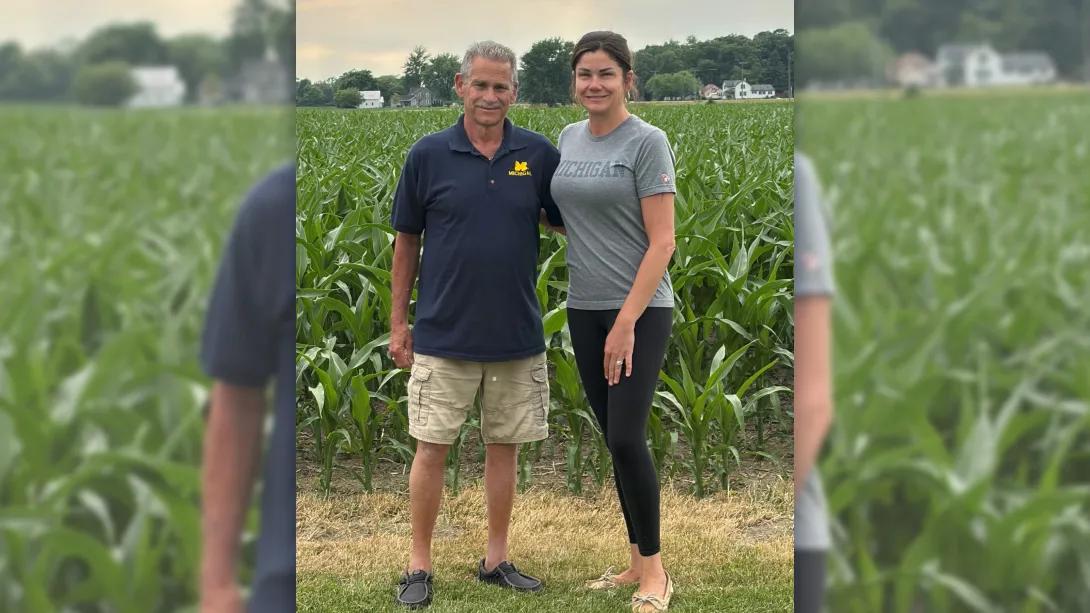 Father and daughter smiling in a cornfield outdoors