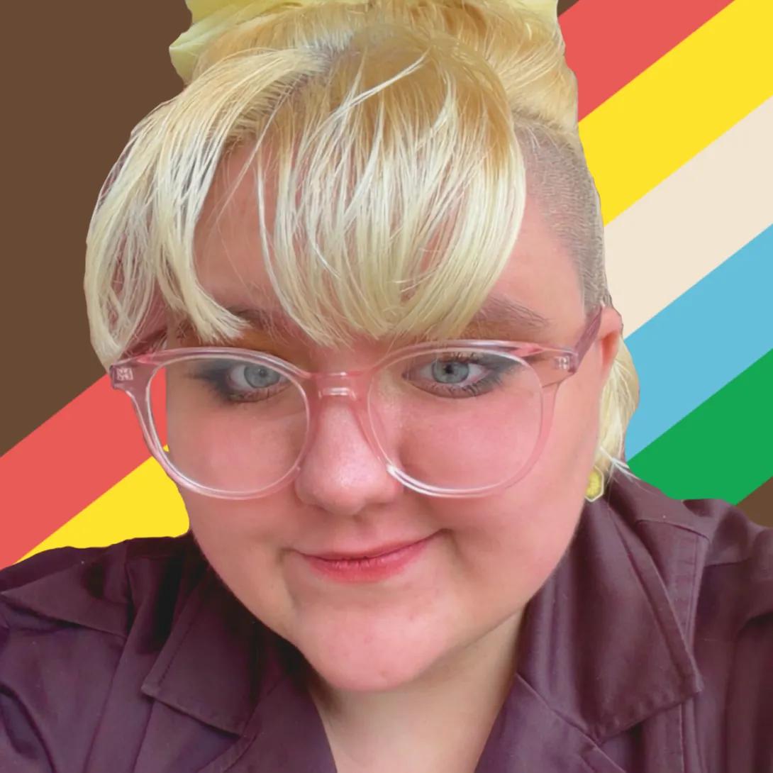 A photo of Chance Whitney, who describes themself as having blonde hair, white skin, blue eyes, and cool pink glasses. They're in front of the disability pride flag.