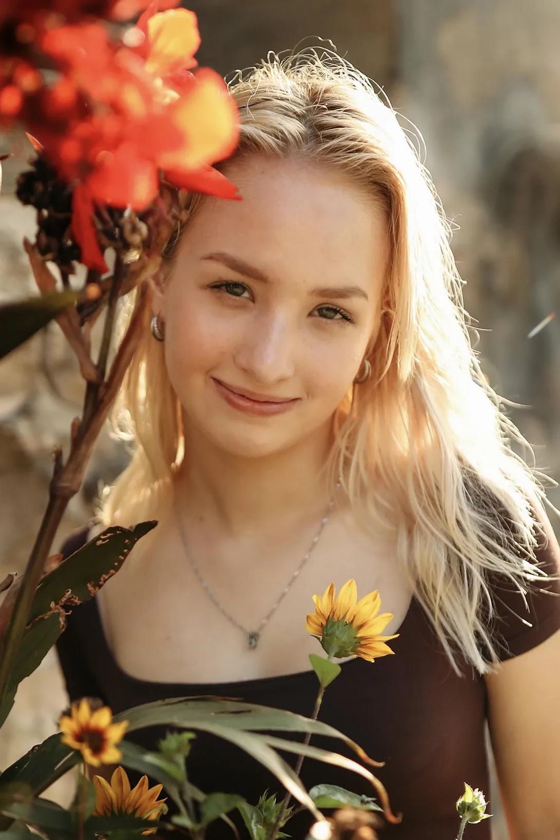 A photo of Melaniya Zazovsky, who describes herself as having blonde hair, pale skin, and hazel eyes.
