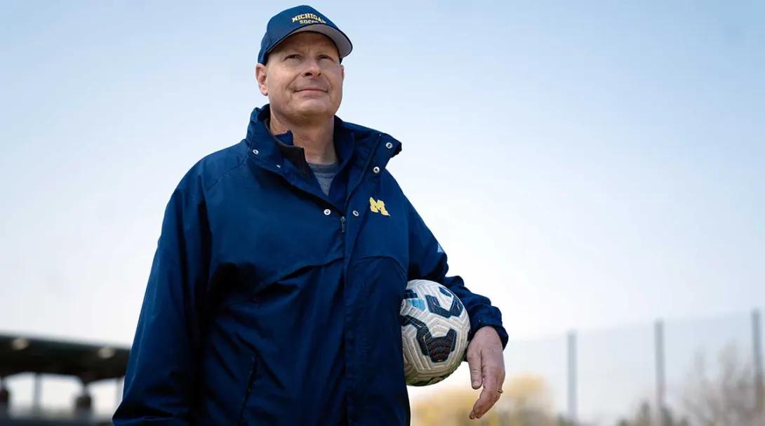 Steve Burns standing with a soccer ball under his arm