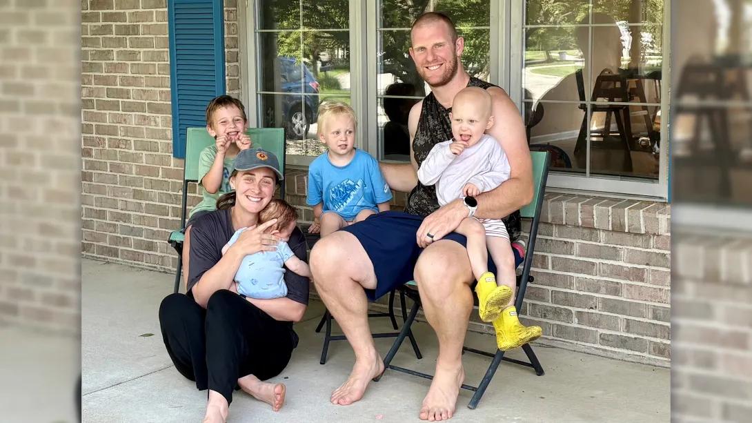 family with 4 kids smiling outside