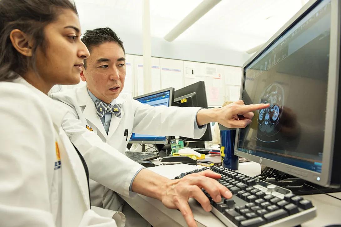 Instructor pointing out a on a computer monitor
